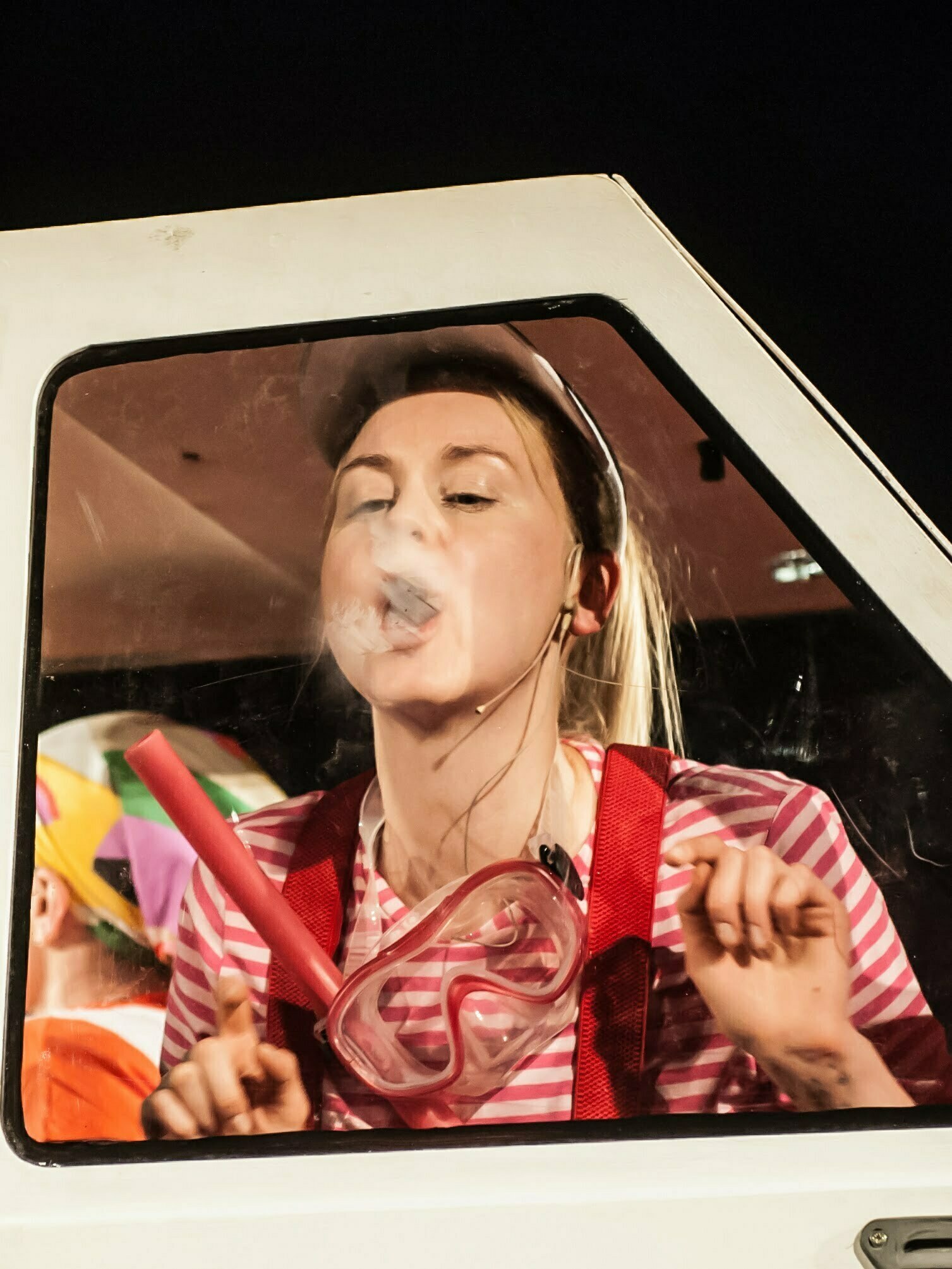Zdjęcie ze spektaklu Ja, Maluch i morze. Mała dziewczynka siedząca w samochodzie trzyma w ręku okulary do nurkowania. Dmucha na szybę.